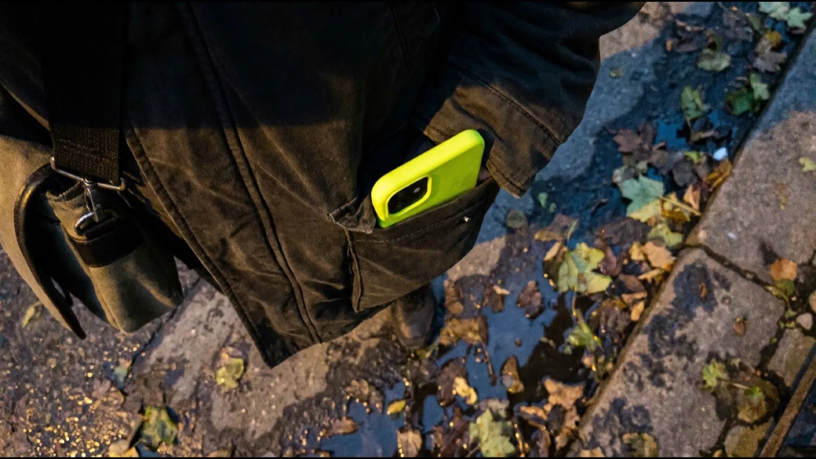 A phone in a jacket pocket seen from above while walking